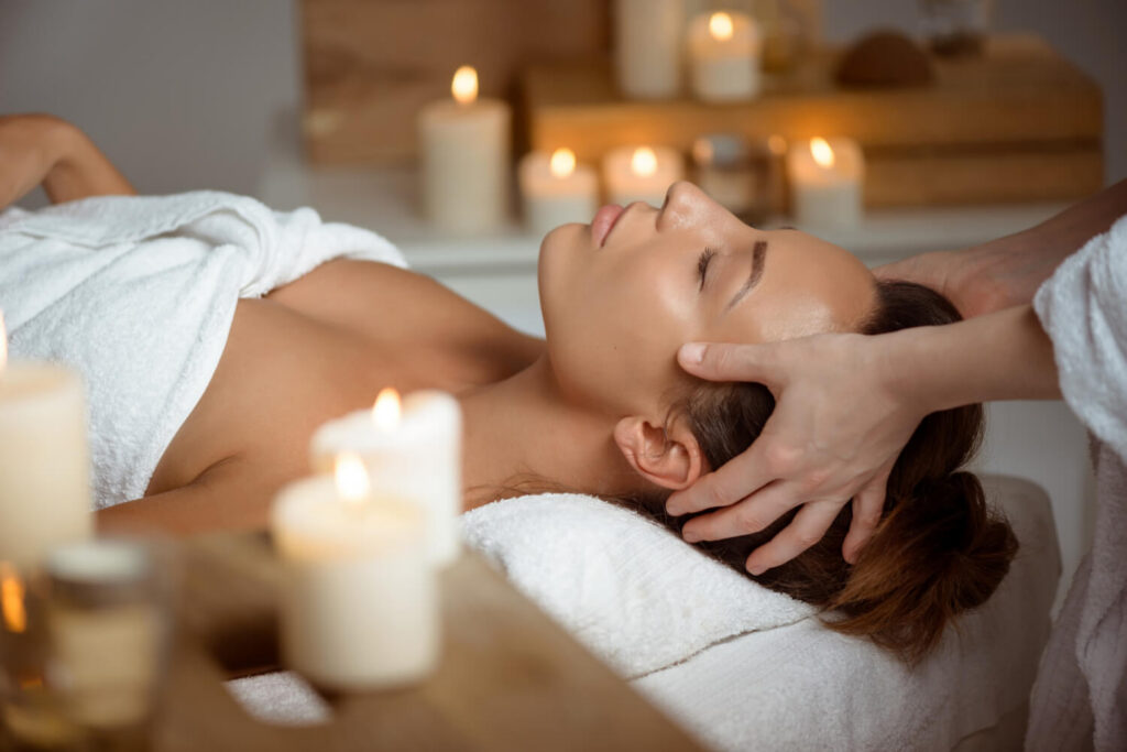 Kobieta podczas relaksacyjnego rytuału SPA z masażem twarzy